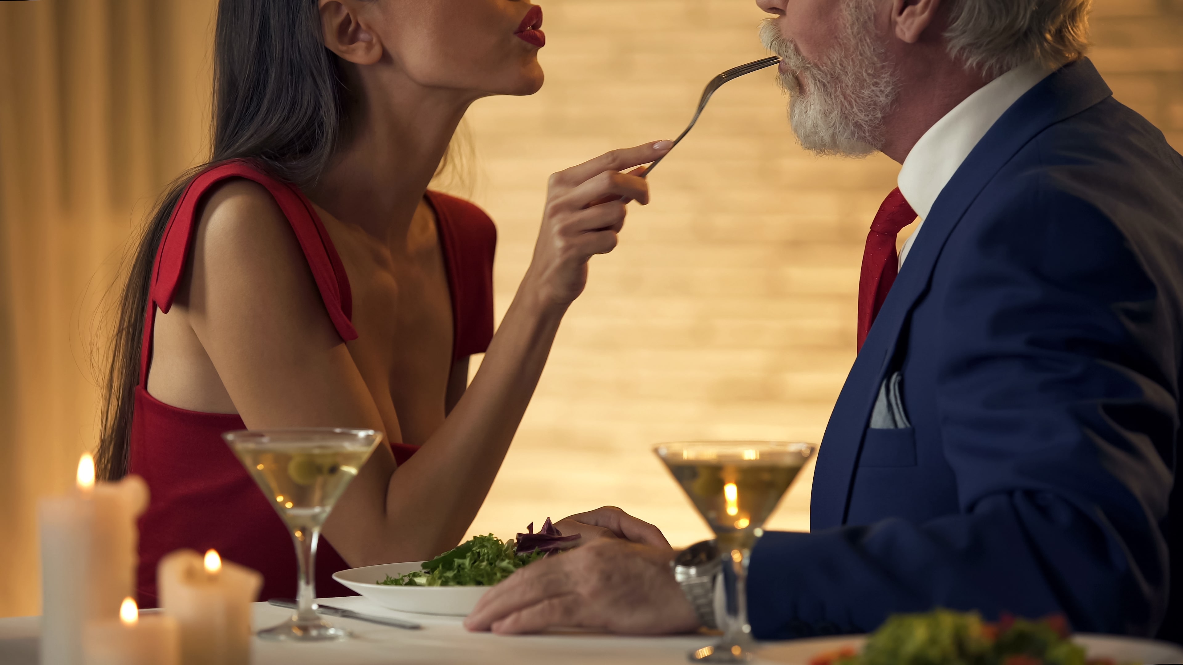 young woman feeding old man dinner